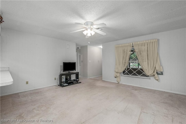 unfurnished living room featuring a textured ceiling, ceiling fan, and carpet flooring