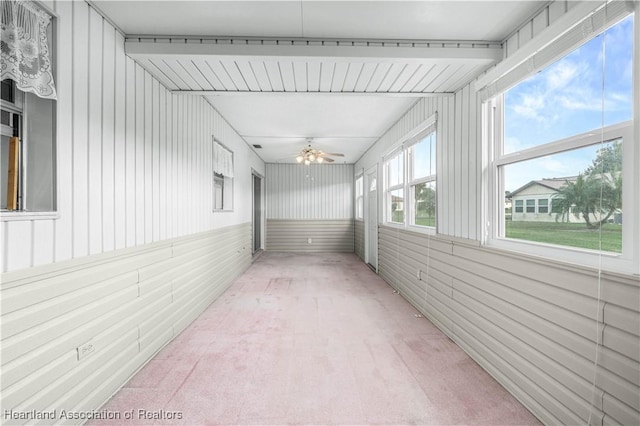 unfurnished sunroom with ceiling fan