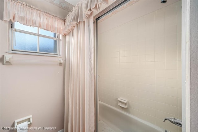 bathroom with bath / shower combo with glass door