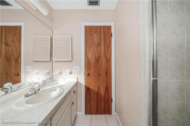 bathroom featuring tile patterned floors, an enclosed shower, and vanity