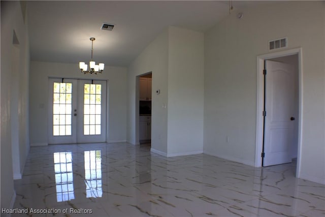 empty room with french doors, an inviting chandelier, and lofted ceiling