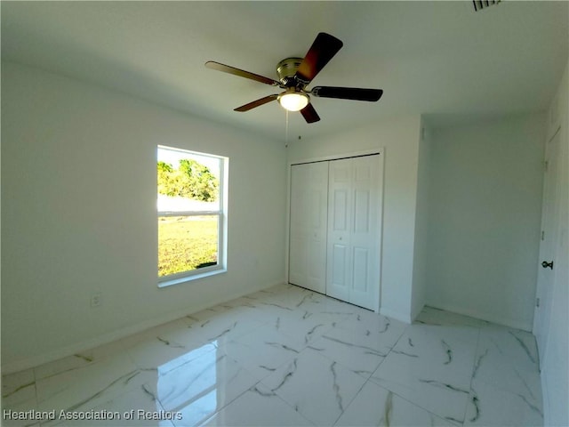 unfurnished bedroom featuring ceiling fan and a closet