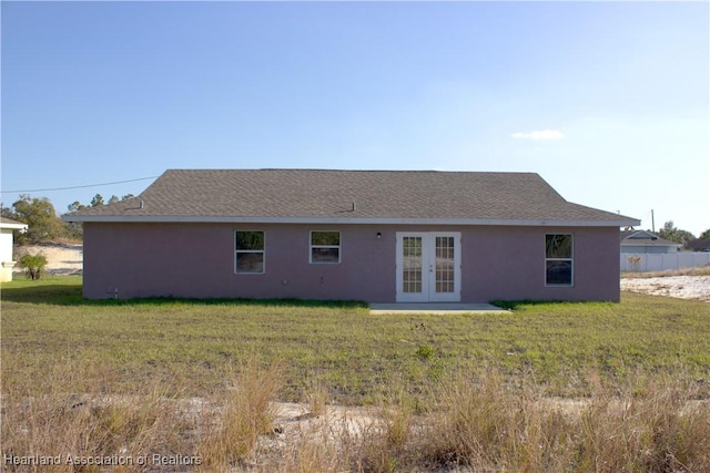 rear view of house featuring a lawn and french doors