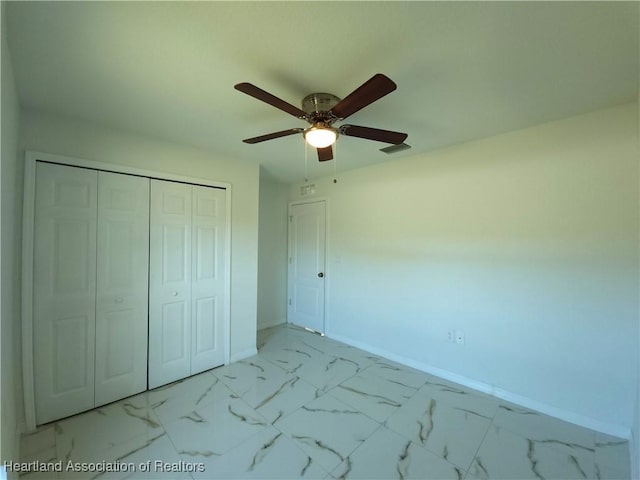 unfurnished bedroom with ceiling fan and a closet