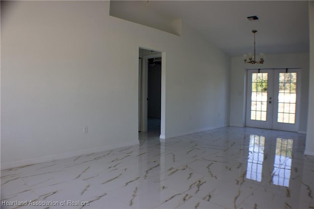 empty room with french doors and a chandelier