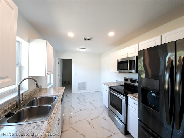 kitchen featuring white cabinetry, sink, and appliances with stainless steel finishes