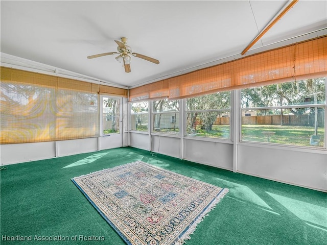 unfurnished sunroom with ceiling fan