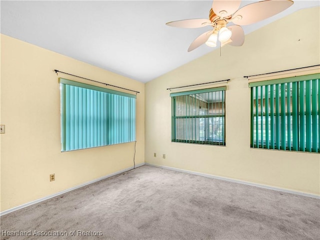 carpeted spare room featuring ceiling fan and vaulted ceiling