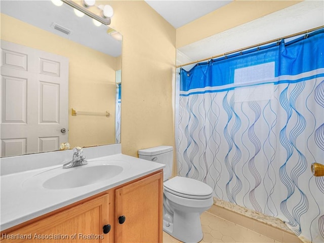 bathroom featuring vanity, a shower with shower curtain, tile patterned floors, and toilet