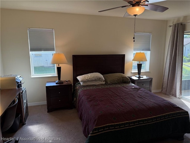 bedroom with multiple windows, ceiling fan, and light carpet