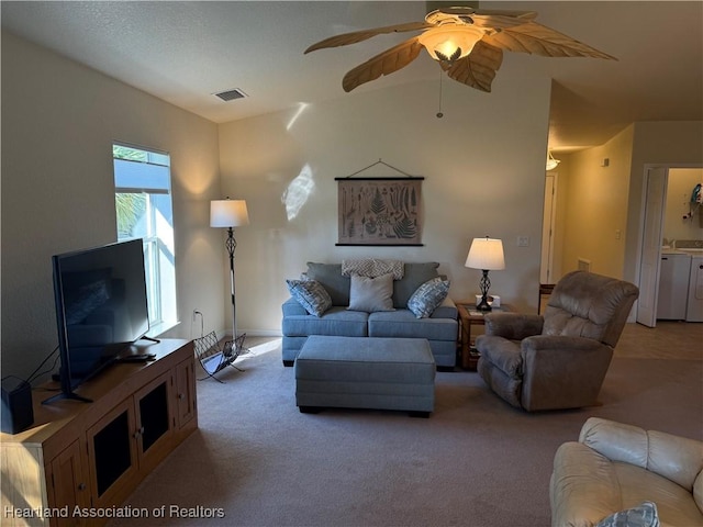 carpeted living room featuring washing machine and dryer and ceiling fan