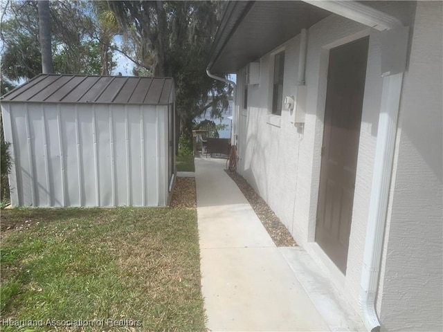 view of side of home with an outbuilding, metal roof, a yard, a shed, and a standing seam roof