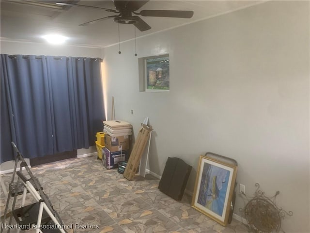 spare room featuring ceiling fan and baseboards