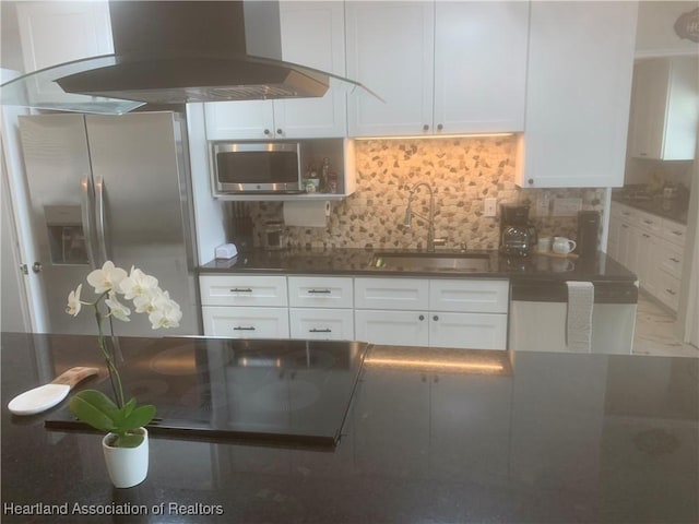 kitchen featuring island range hood, appliances with stainless steel finishes, backsplash, and a sink