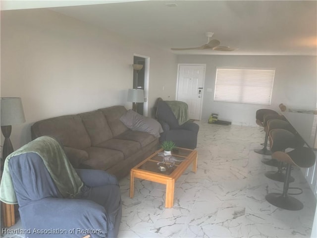 living area featuring marble finish floor and ceiling fan