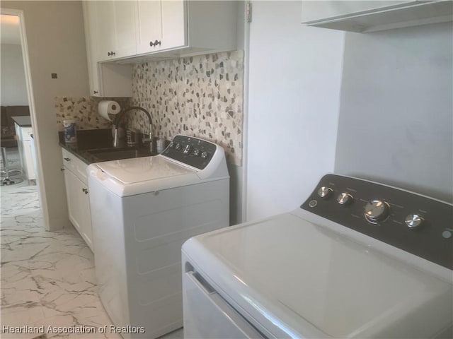 clothes washing area featuring a sink, marble finish floor, cabinet space, and washing machine and clothes dryer