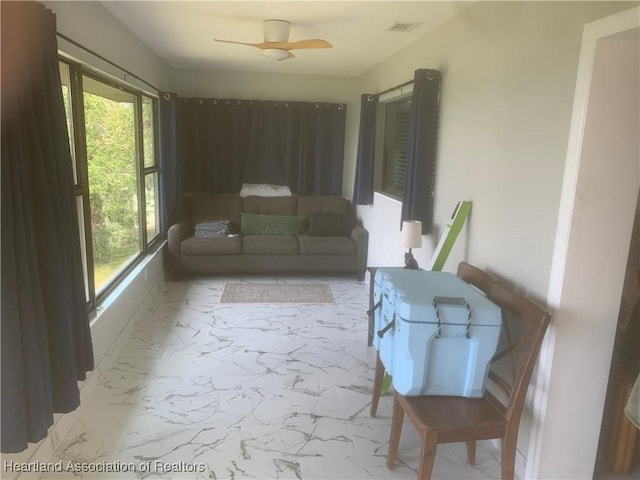 living room featuring ceiling fan, marble finish floor, and visible vents