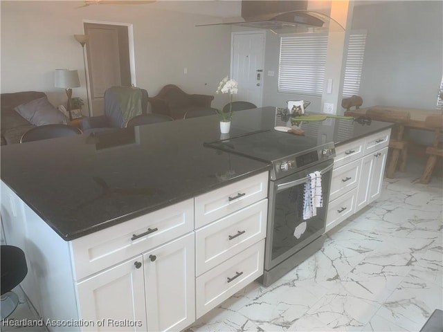 kitchen with a kitchen island, white cabinets, open floor plan, marble finish floor, and stainless steel range with electric stovetop