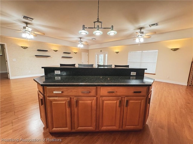 5717 Longbow Dr, Sebring, FL 33876 - kitchen with a ceiling fan, light wood-style flooring, and brown cabinetry