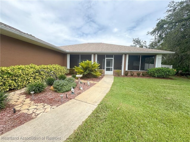 5717 Longbow Dr, Sebring, FL 33876 - view of front of house with a front yard, stucco siding, and a sunroom