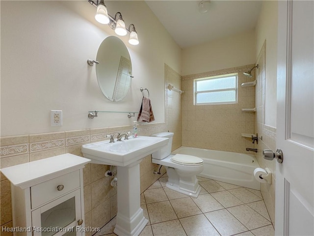 5717 Longbow Dr, Sebring, FL 33876 - bathroom featuring tile walls, tile patterned floors, tub / shower combination, and a wainscoted wall