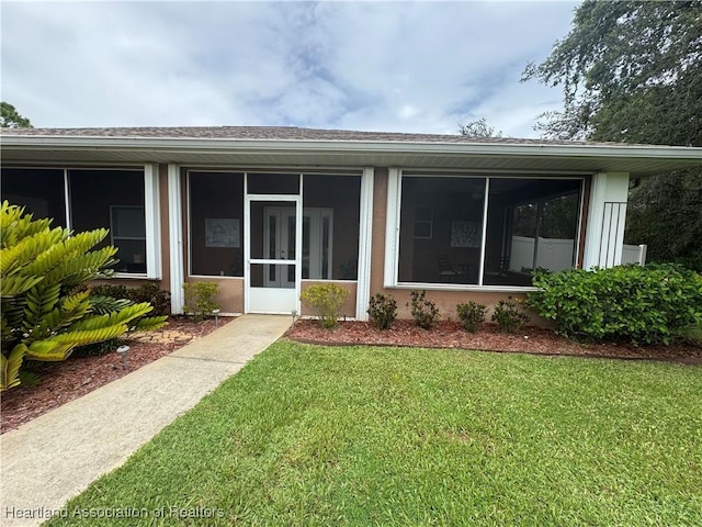 5717 Longbow Dr, Sebring, FL 33876 - view of exterior entry featuring a lawn and roof with shingles