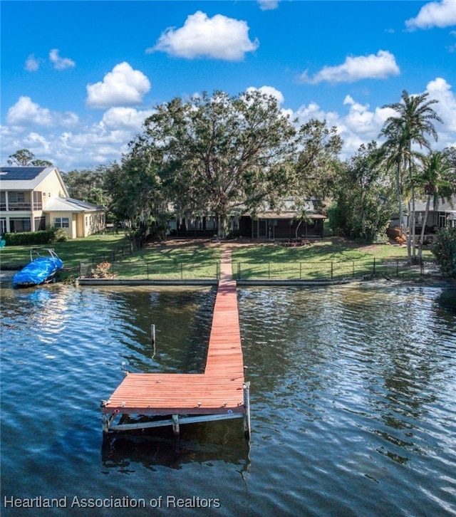 dock area with a yard and a water view