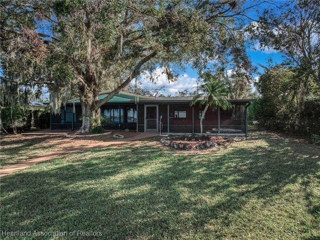 back of house with a sunroom and a lawn