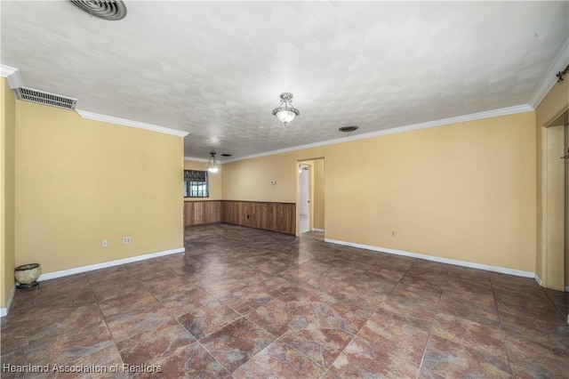 unfurnished room with a textured ceiling, wooden walls, and ornamental molding