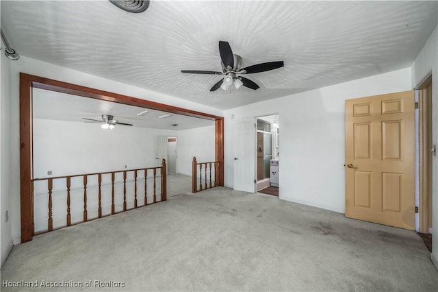 spare room with ceiling fan and carpet