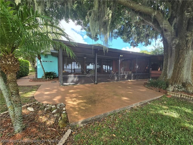 rear view of property featuring a lanai and a patio area