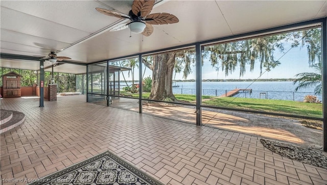 unfurnished sunroom with a water view and ceiling fan