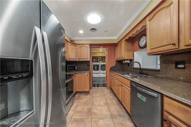 kitchen with tasteful backsplash, stainless steel appliances, sink, independent washer and dryer, and light tile patterned flooring