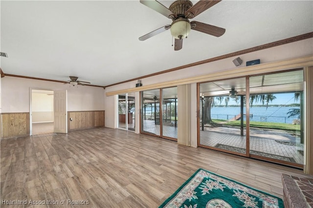 unfurnished living room with a water view, crown molding, light hardwood / wood-style flooring, and ceiling fan