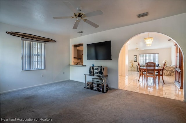 671 Lake Tina Dr, Lake Placid, FL 33852 - carpeted living area featuring arched walkways, a ceiling fan, a chandelier, and baseboards