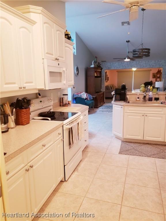 6401 Matanzas Dr, Sebring, FL 33872 - kitchen featuring white appliances, a sink, a ceiling fan, lofted ceiling, and light countertops