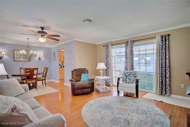 living room featuring hardwood / wood-style floors, ceiling fan with notable chandelier, a textured ceiling, and crown molding