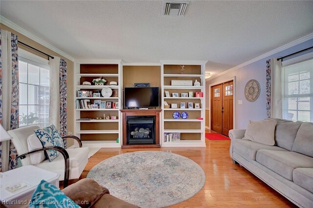 living room with hardwood / wood-style flooring, crown molding, and a textured ceiling