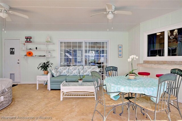 tiled dining area with crown molding and ceiling fan