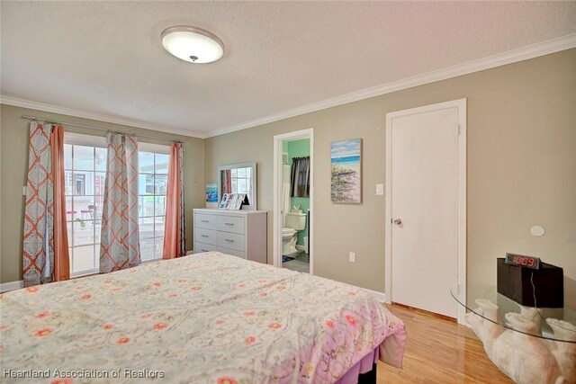 bedroom featuring ensuite bathroom, light hardwood / wood-style flooring, a spacious closet, and ornamental molding