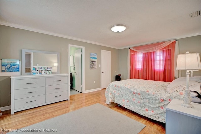 bedroom with light wood-type flooring, ensuite bath, and crown molding