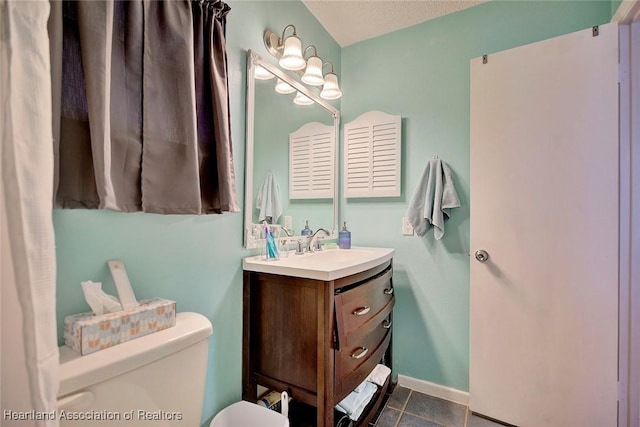 bathroom with tile patterned floors, vanity, a textured ceiling, and toilet