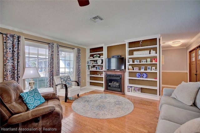 living room featuring hardwood / wood-style floors, a textured ceiling, and crown molding