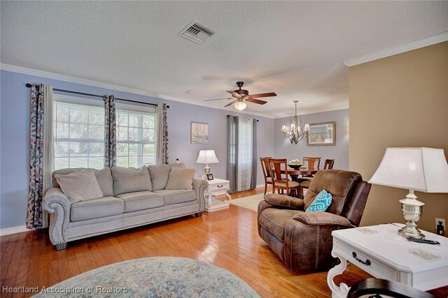 living room featuring light hardwood / wood-style floors, crown molding, and a wealth of natural light