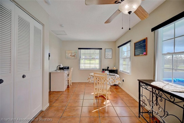 tiled home office featuring ceiling fan and a textured ceiling