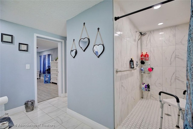 bathroom featuring a tile shower and a textured ceiling