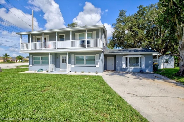 view of property with a balcony and a front yard