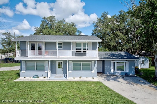 view of front of property with a balcony, a porch, and a front lawn