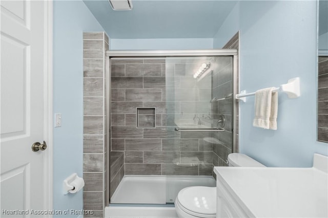 bathroom with vanity, an enclosed shower, and toilet