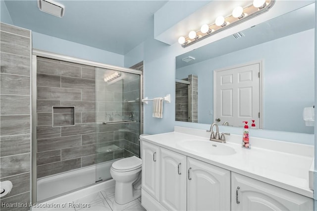 bathroom featuring a shower with door, vanity, and toilet